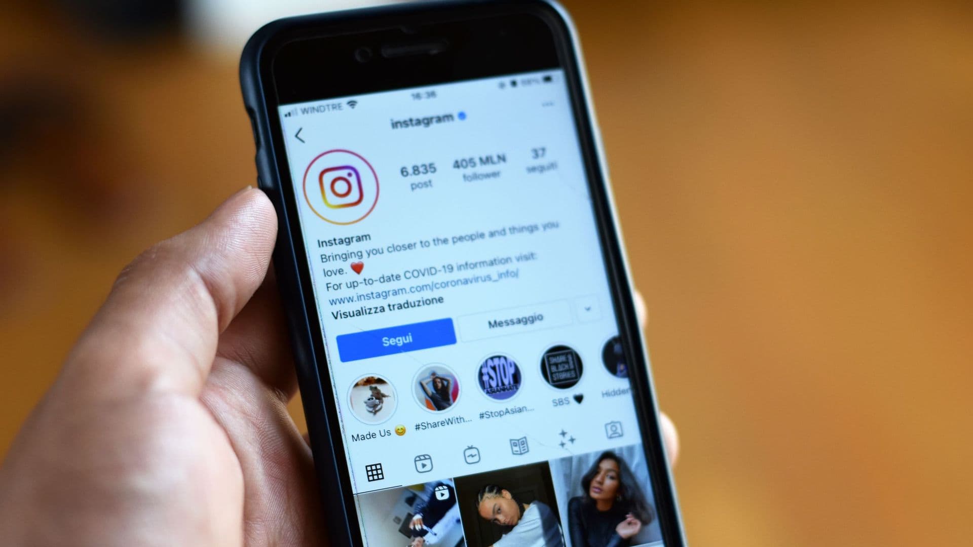 Mão a segurar um telemóvel com um perfil de Instagram aberto