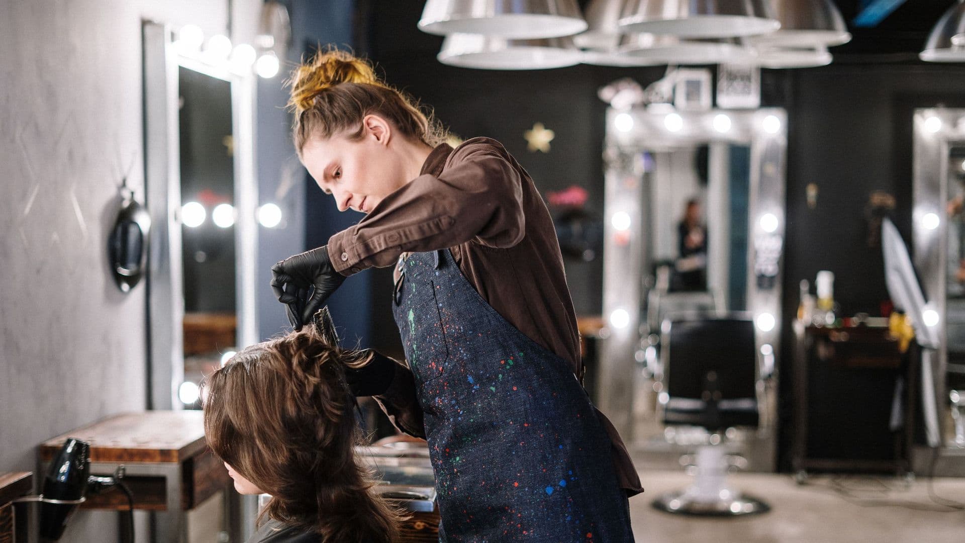 Cabeleireira a aplicar coloração no cabelo de uma cliente