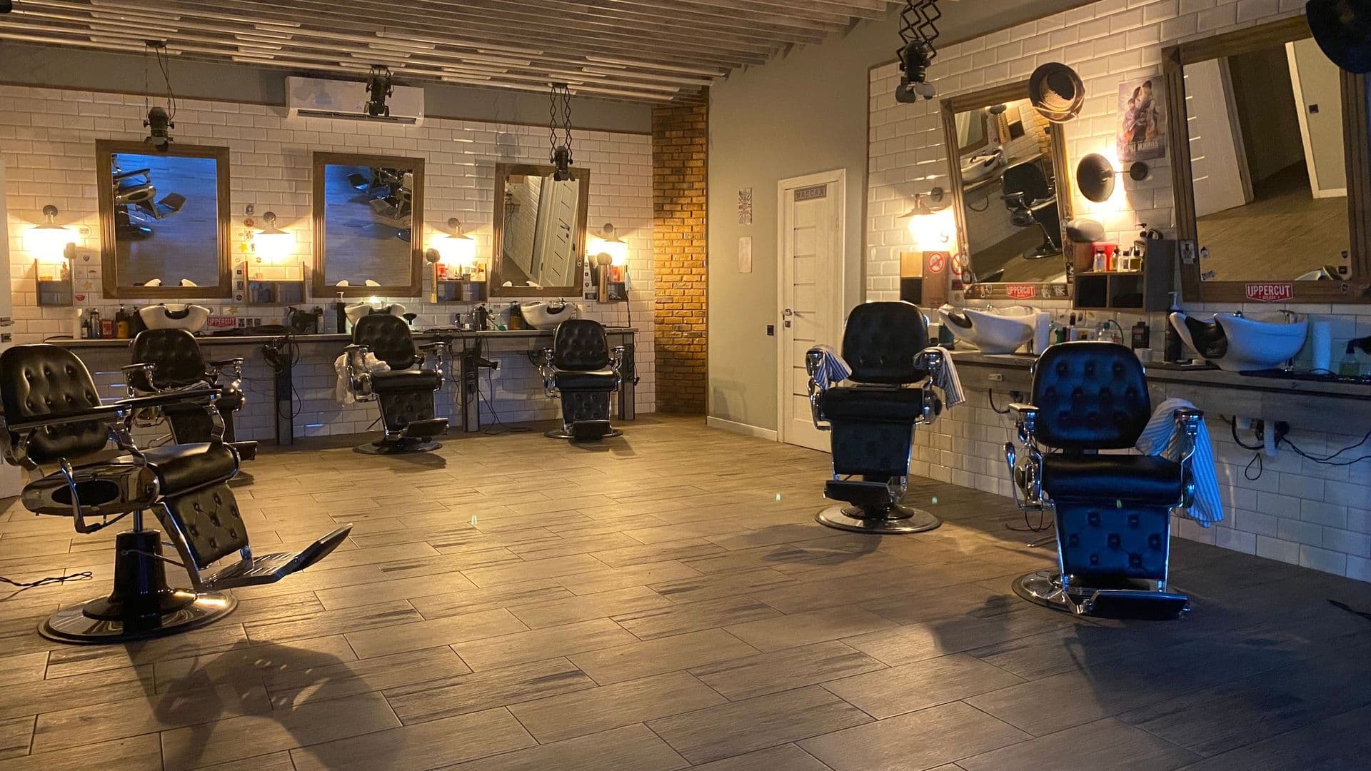 Interior de uma barbearia com cadeiras de barbeiro clássicas, espelhos e lavatórios