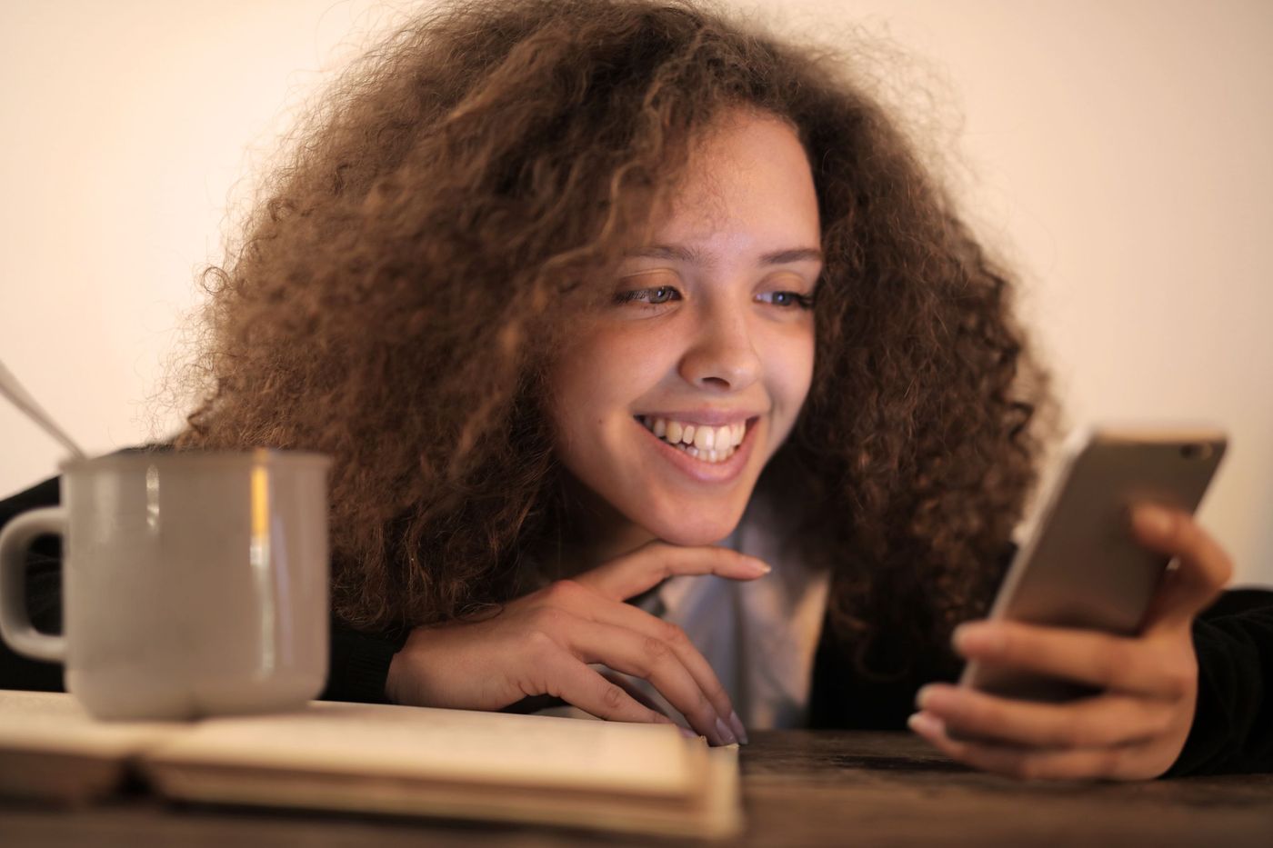 Mulher sorridente a escrever no telemóvel