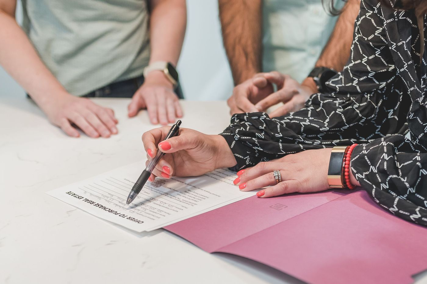 Mãos assinando um contrato em uma mesa de reunião