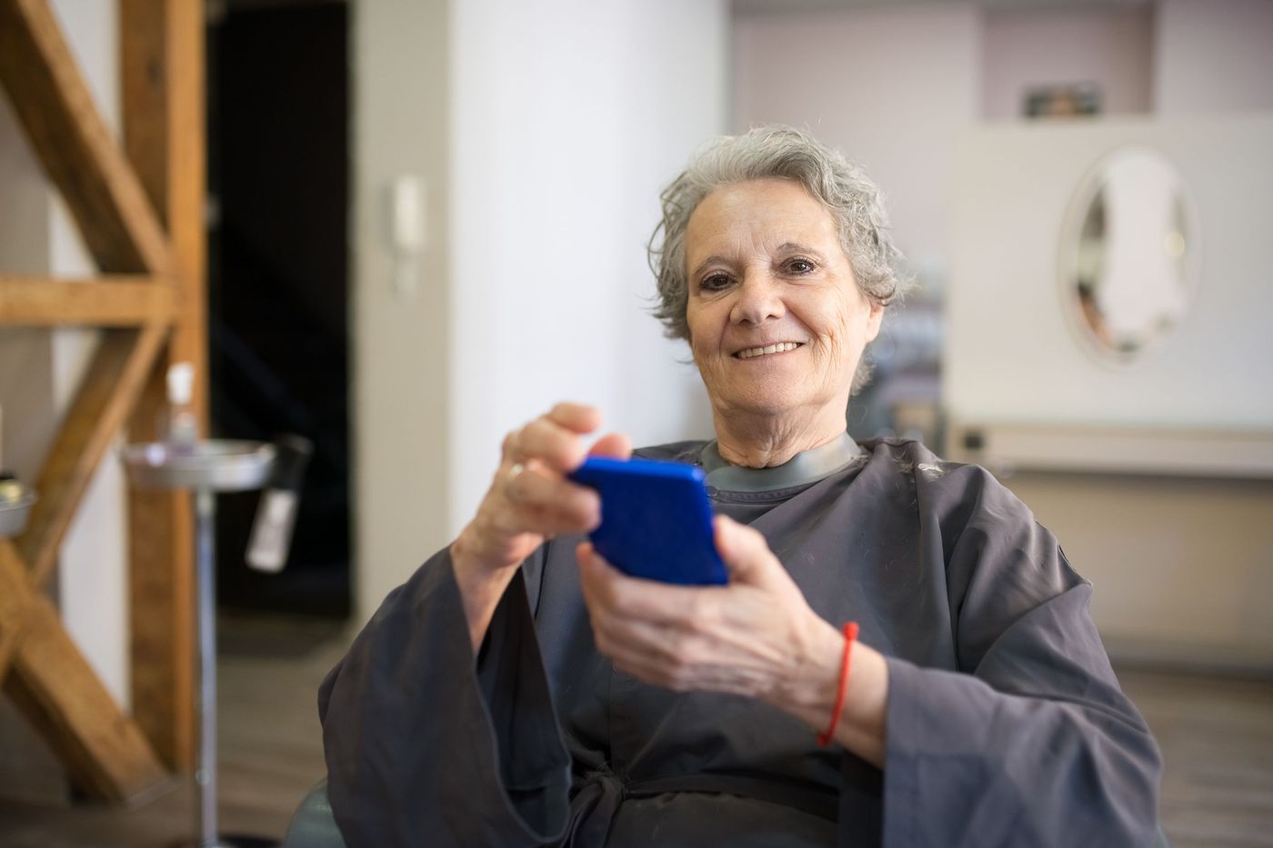 Cliente sentada num salão a usar o telemóvel