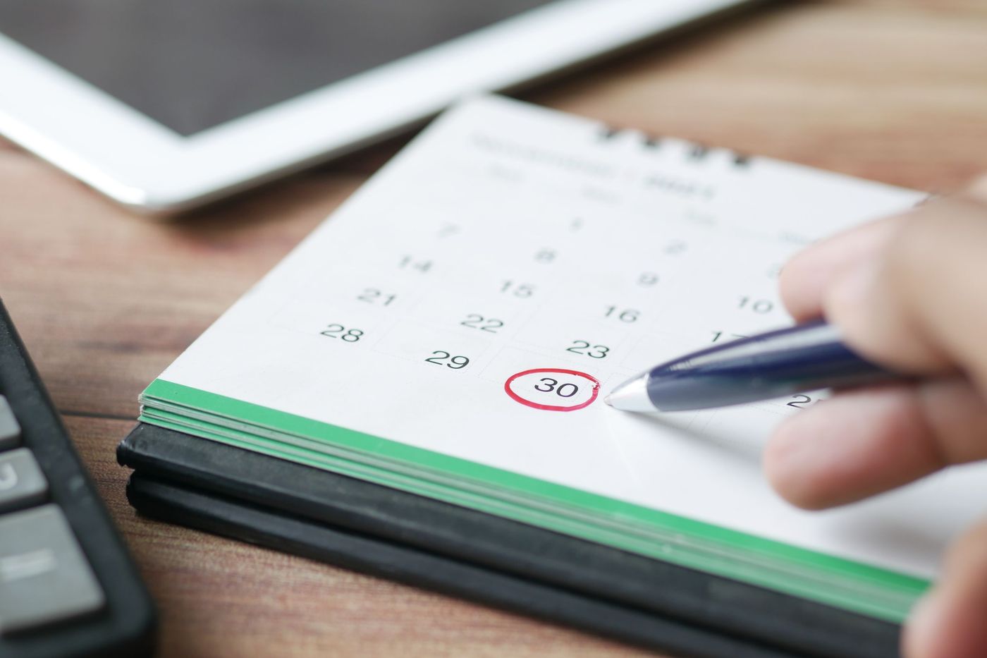 Mão a assinalar um dia num calendário de papel